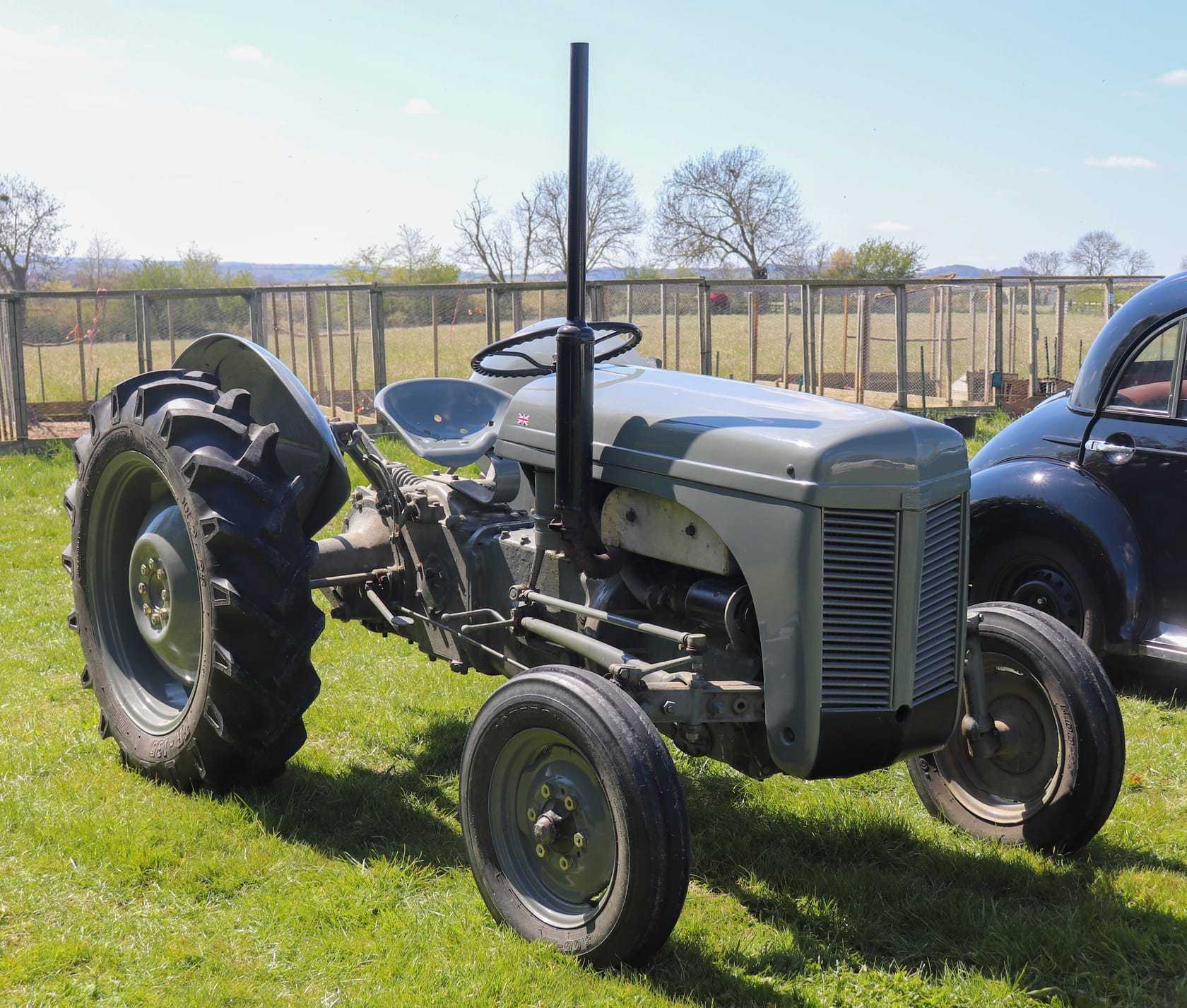 A grey Ferguson TE20 tractor, front three-quarter view, showing the upright exhaust and the single shade of grey paint, standing in a field