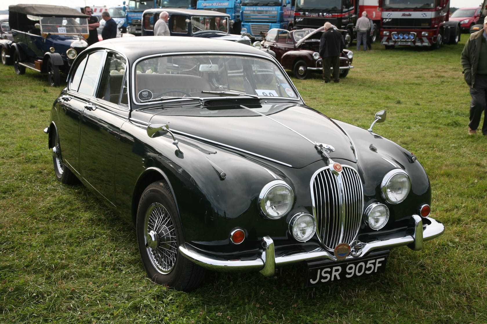 A dark green Jaguar Mk2 saloon, front three-quarter view, on grass at a classic car show