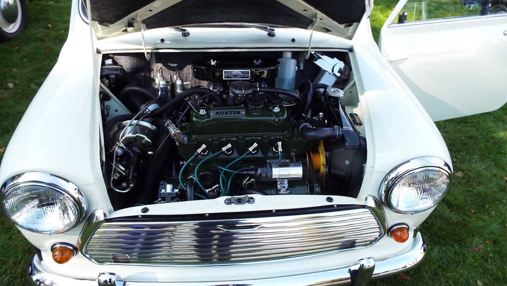 The open engine bay of a 1969 Austin Mini showing the transverse A-series engine, carburettor and wiring