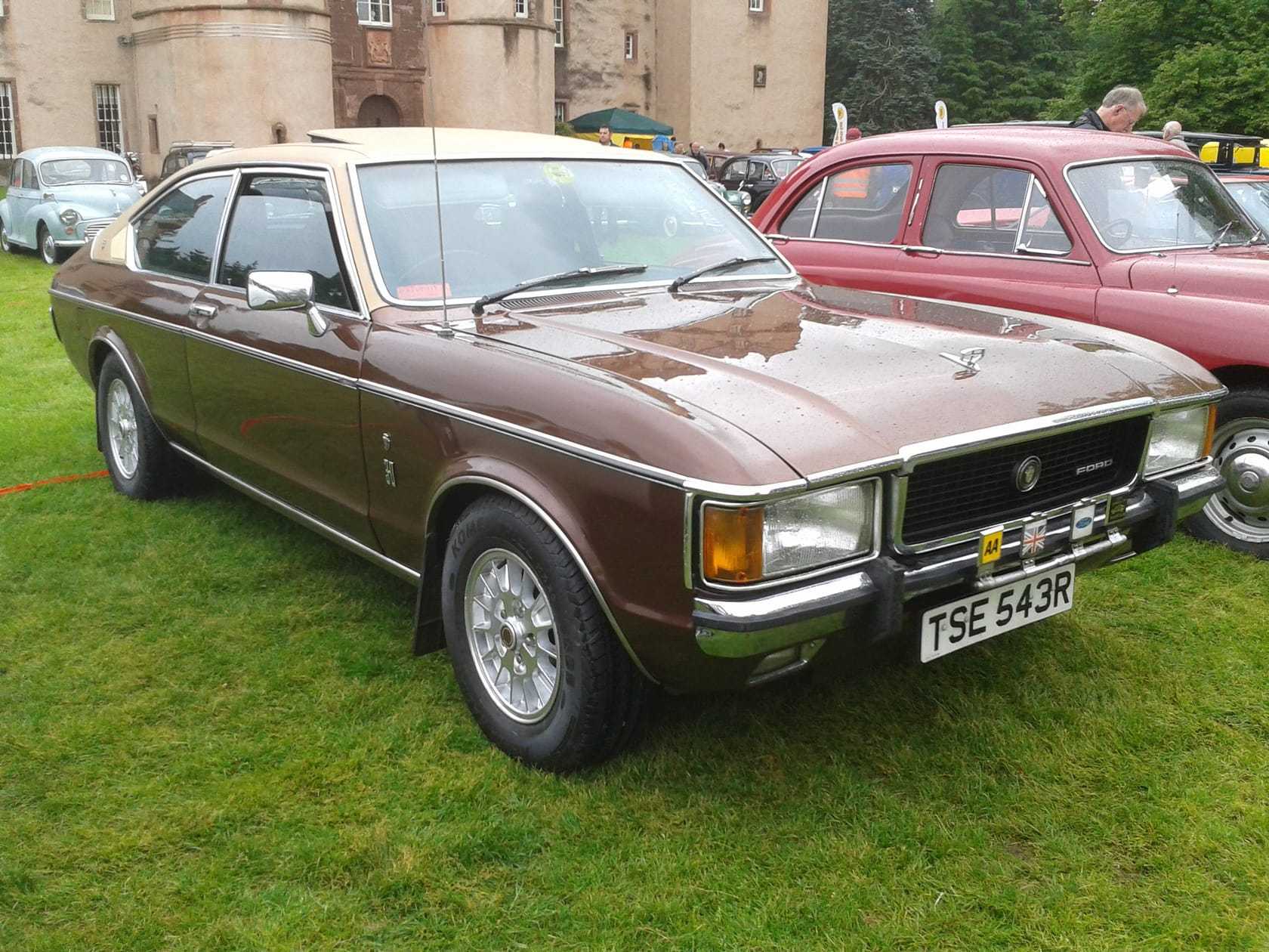 A brown Ford Granada Mk1 coupe at a show in front of a castle, front three-quarter view