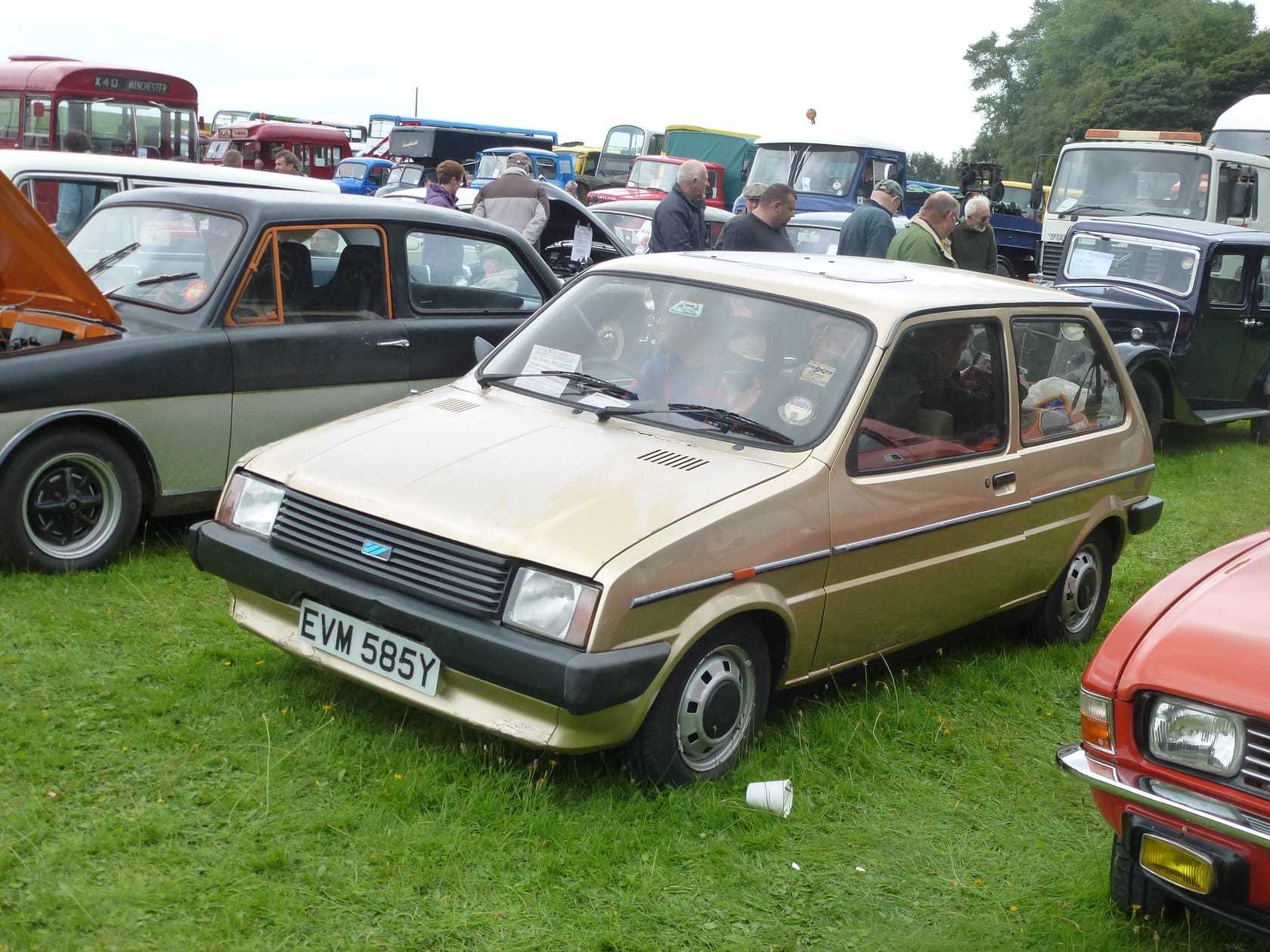 A gold 1983 Austin Metro at a classic car show, front three-quarter view, UK registration EVM 585Y