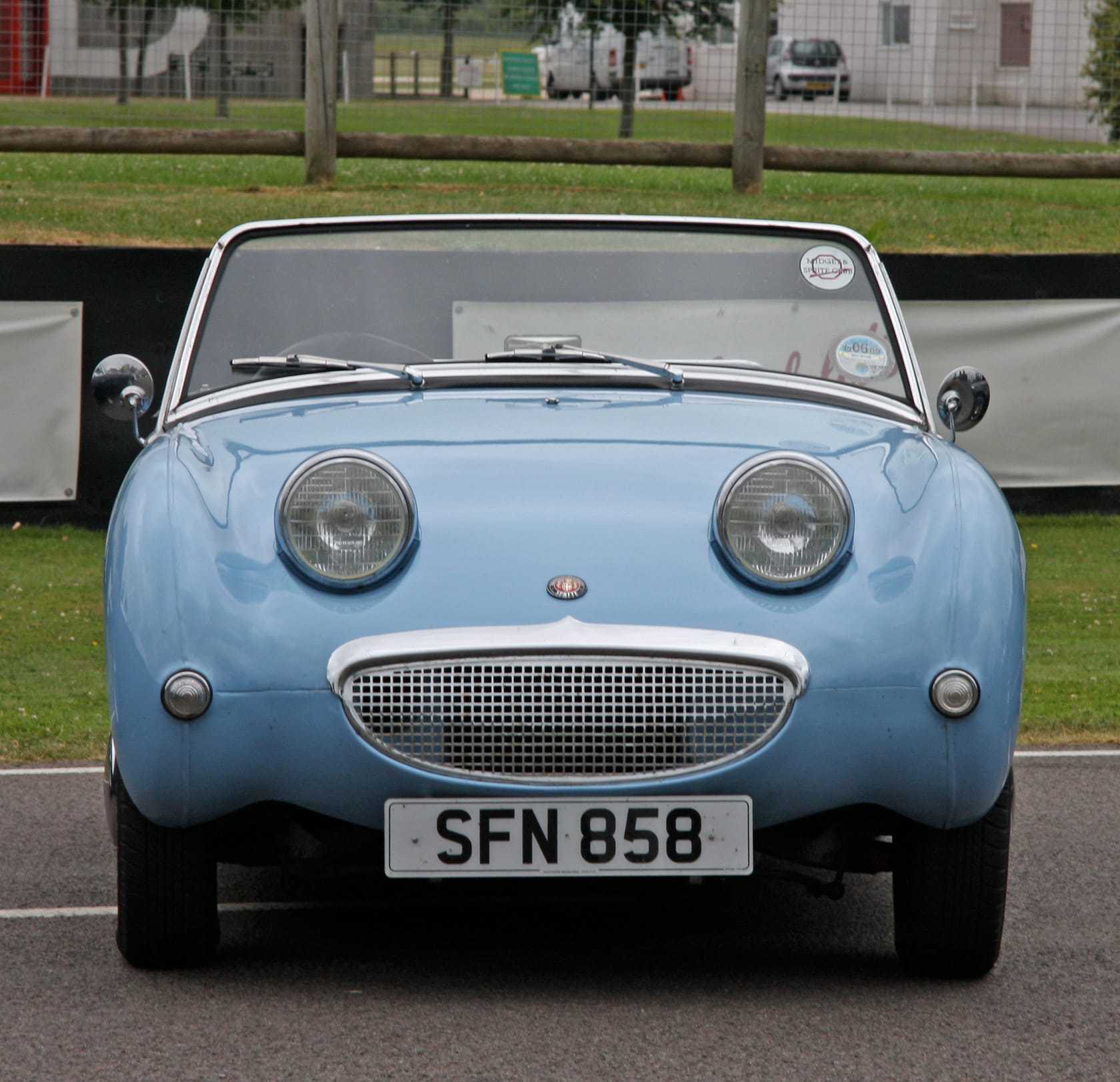 A light blue Frogeye Sprite with UK registration SFN 858 photographed head-on, showing the bonnet-mounted headlamps and grinning grille