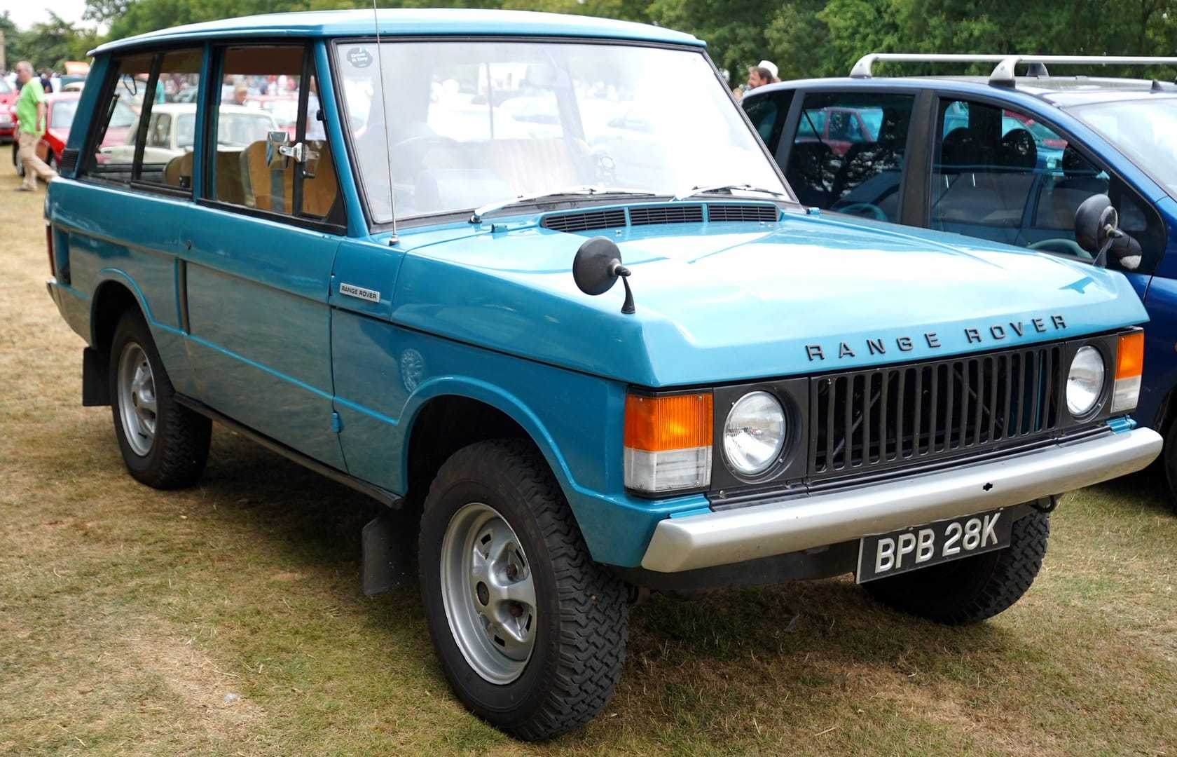 A blue 1972 two-door Range Rover with a UK registration on a show field, front three-quarter view
