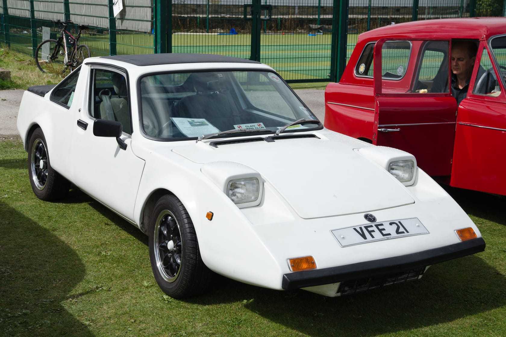 A white Clan Crusader coupe, registration VFE 21, front three-quarter view on grass at a classic car show