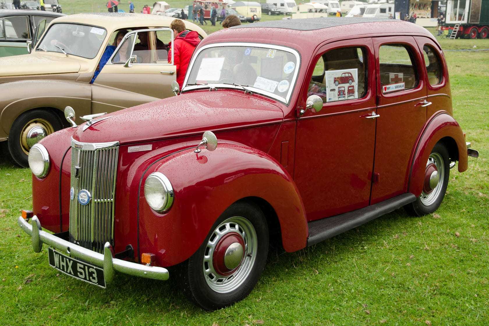 A maroon upright Ford Prefect E493A saloon at a show, front three-quarter view
