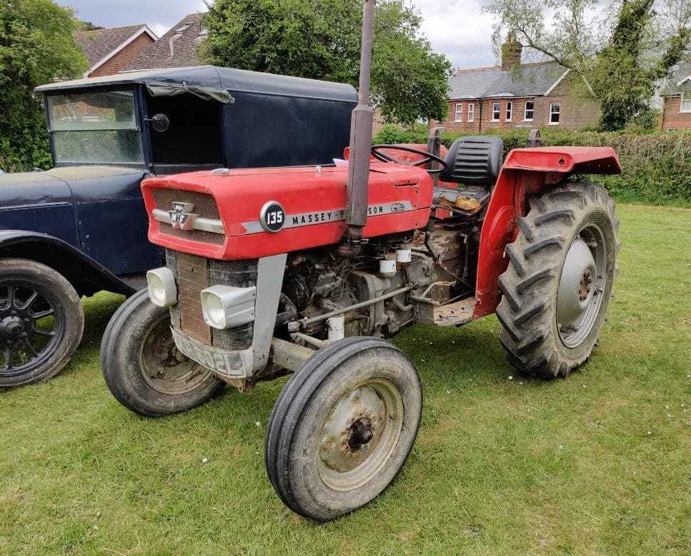 A red Massey Ferguson 135 tractor, front three-quarter view, the 135 badge and grey skid unit clearly visible, parked on grass
