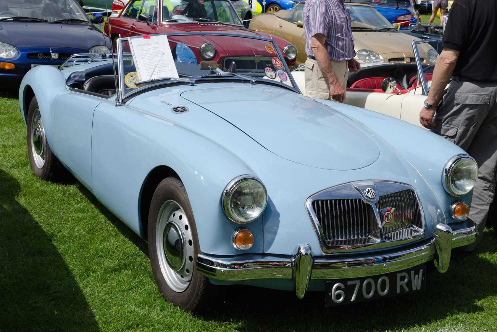 A pale blue 1961 MGA 1600 Mk II roadster with a UK registration and its hood down, on a show field