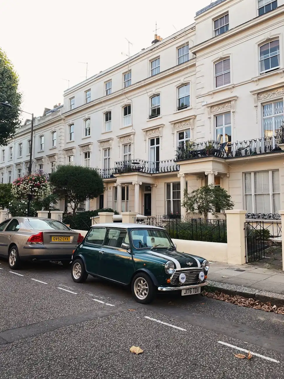 A green Mini Cooper with a white roof on a city street, front view