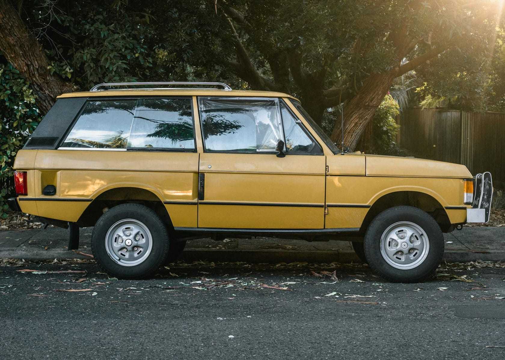 A gold two-door Range Rover Classic in clean side profile at sunset
