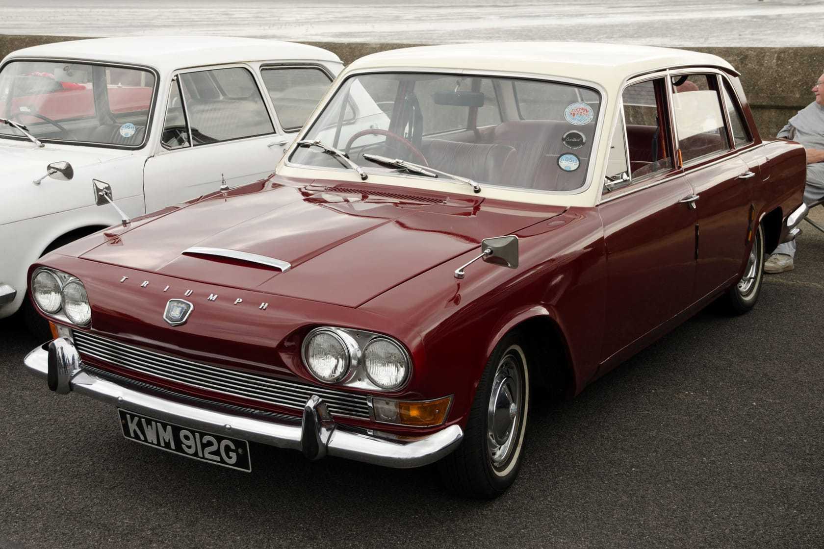 A maroon and white 1968 Triumph 2000 Mk1 with UK registration KWM 912G, front three-quarter view by the seafront