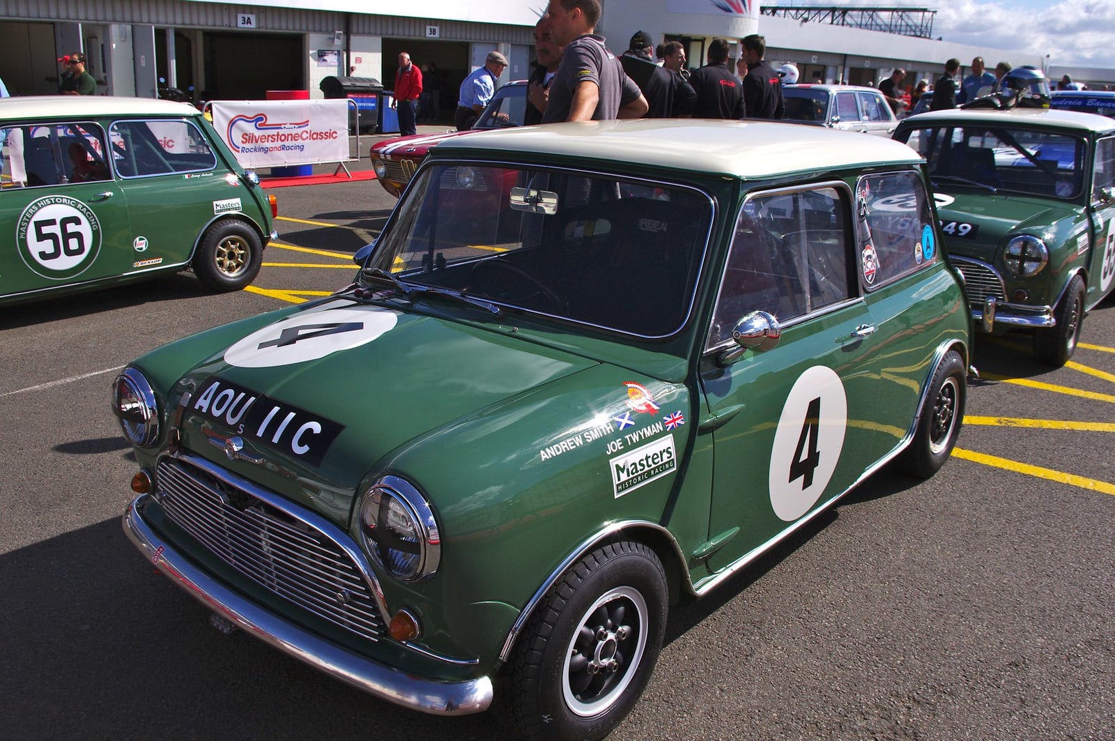 A green Mini Cooper race car at a historic circuit meeting