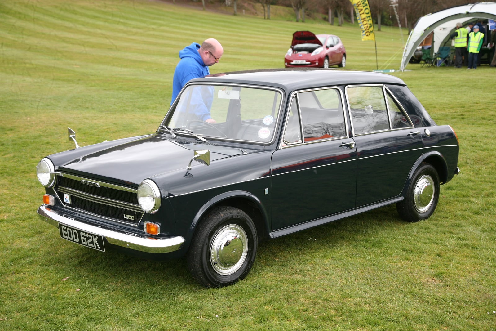 A grey 1972 Austin 1300 four-door saloon, front three-quarter view, on grass at a classic-car show