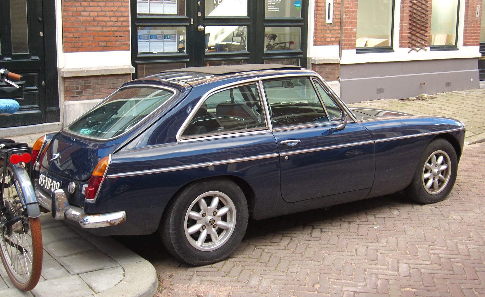 A dark green MG MGB GT, side view on a street