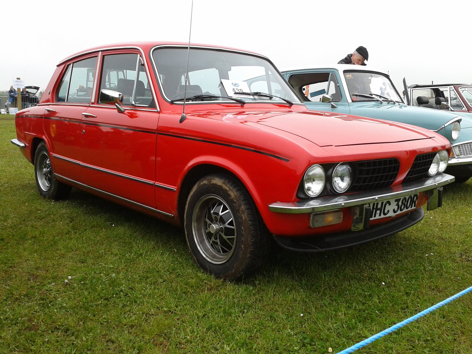 A red Triumph Dolomite 1850, front three-quarter view at a show