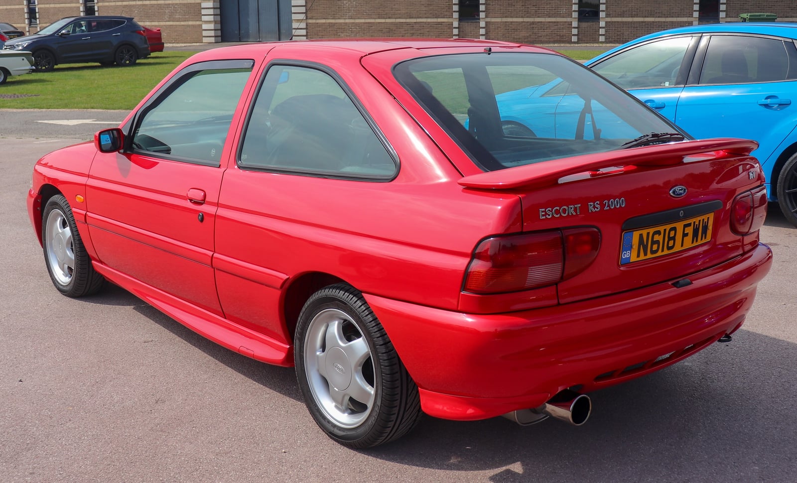A red Ford Escort RS2000, rear three-quarter view with the Escort RS2000 badge and boot spoiler visible