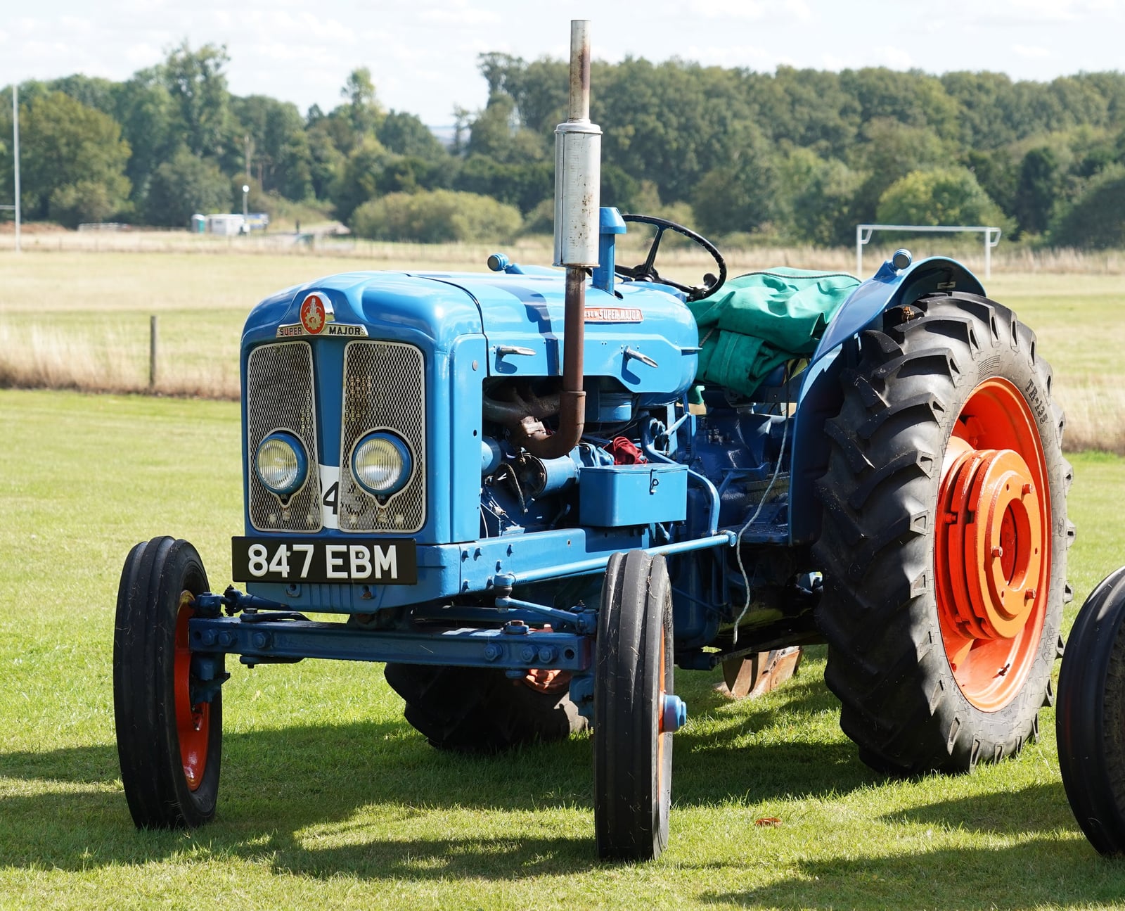 A blue and orange Fordson Super Major, registration 847 EBM, on a show field