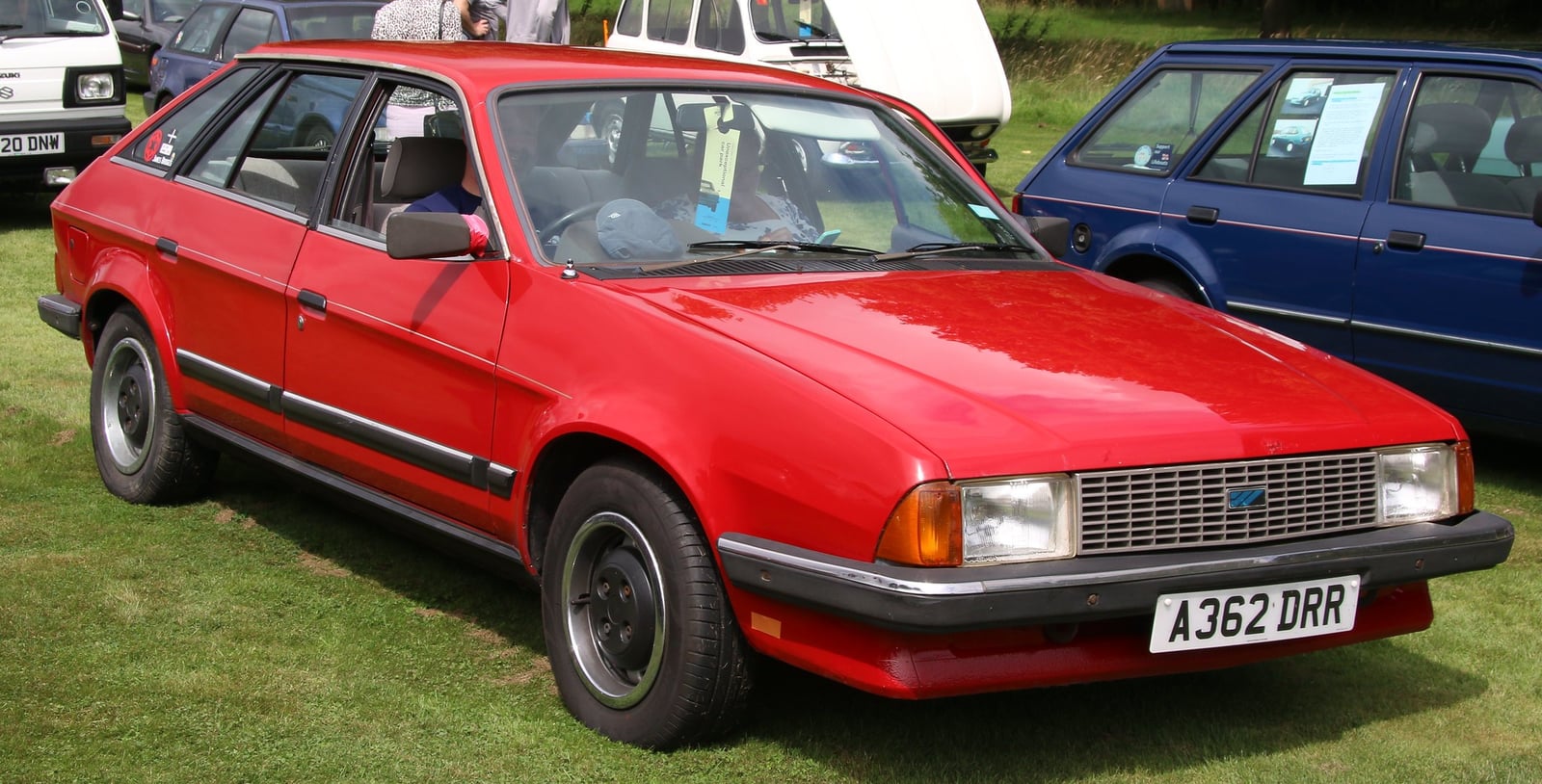 A bright red 1983 Austin Ambassador 2.0HL five-door hatchback (A plate, A362DRR), front three-quarter view on grass at an outdoor classic car show