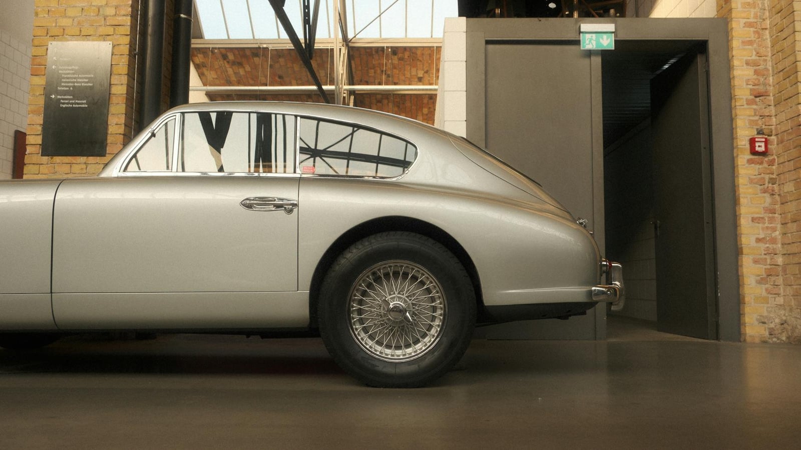 A silver Aston Martin DB5 viewed from the rear three-quarter