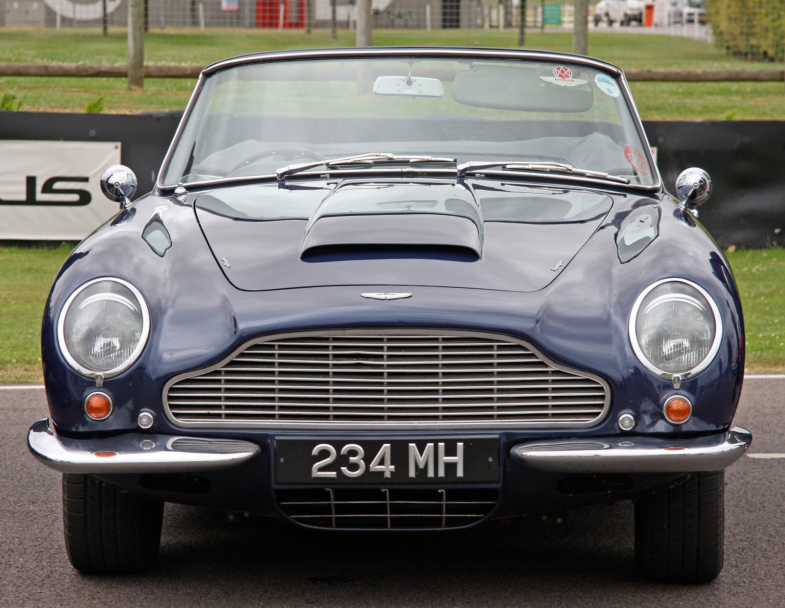 A dark blue Aston Martin DB6 Volante convertible seen head-on, UK registration 234 MH