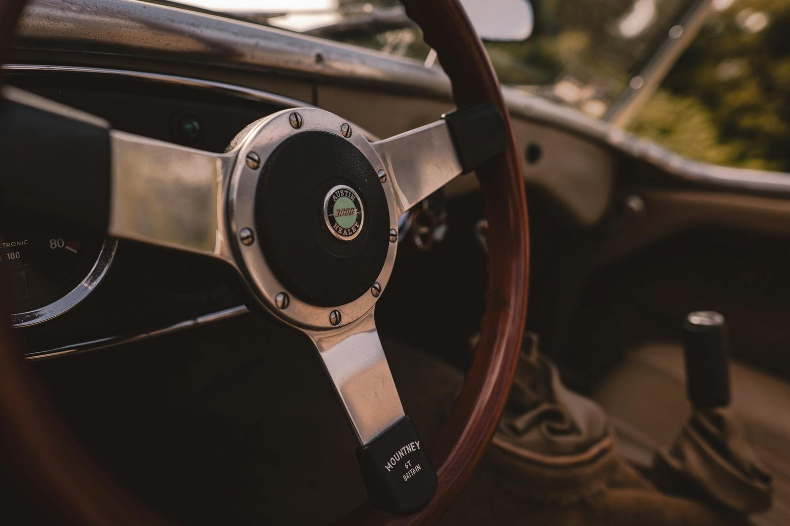 The wood-rimmed steering wheel of an Austin-Healey 3000 with a polished alloy boss