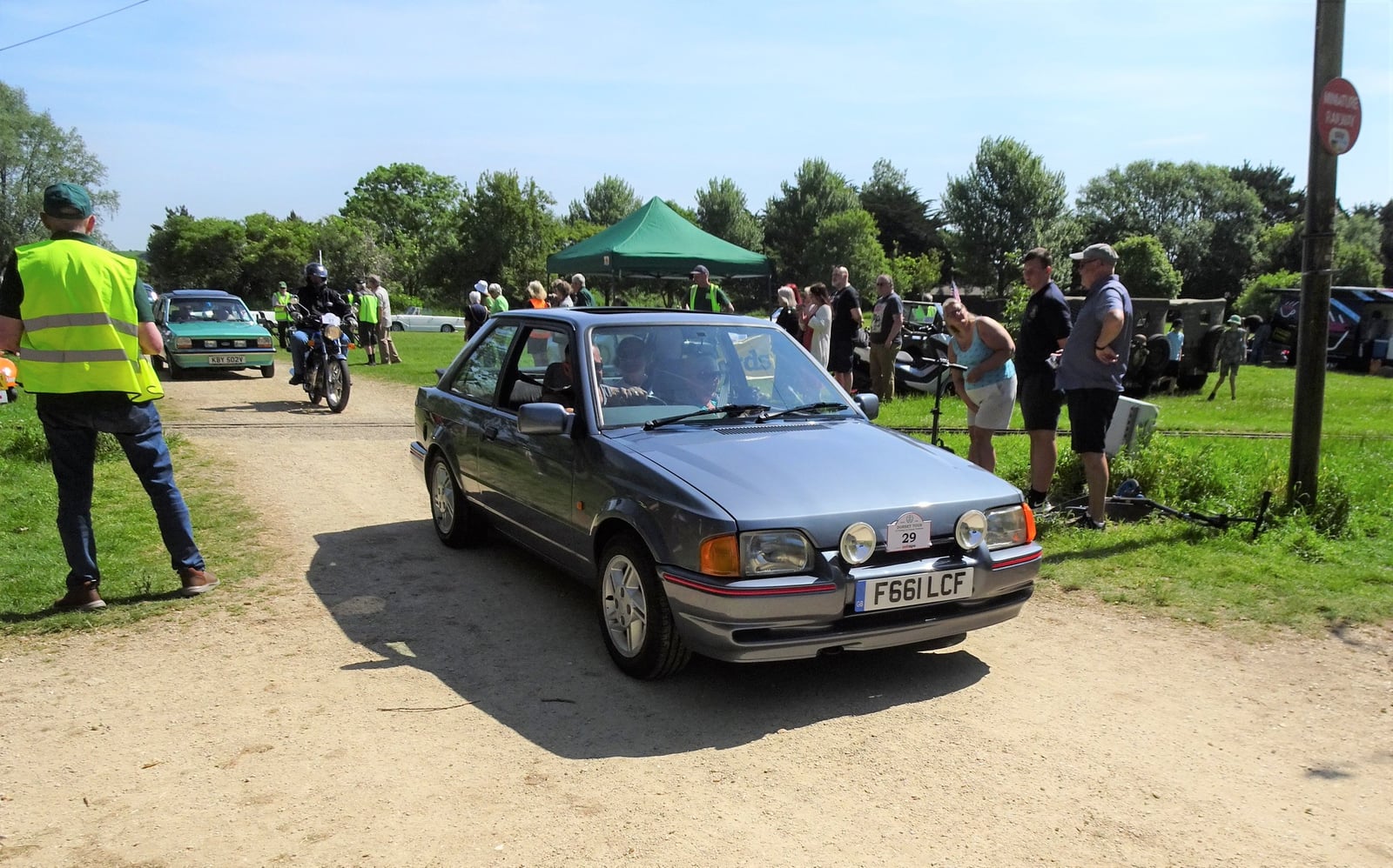 A grey-green Ford Escort XR3i hatchback by the coast, front three-quarter view