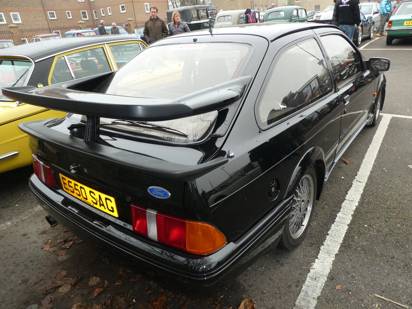A black Ford Sierra RS500 Cosworth, rear three-quarter view, showing its large whale-tail rear spoiler