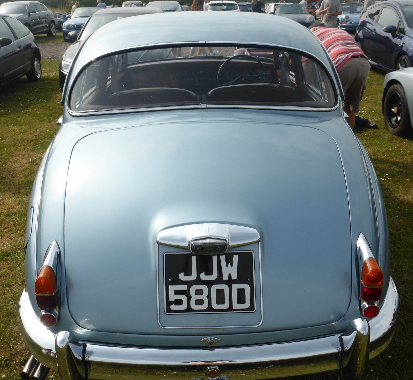The rear of a light blue Jaguar Mk2 saloon at a show, showing the black-on-silver number plate 'JJW 580D'
