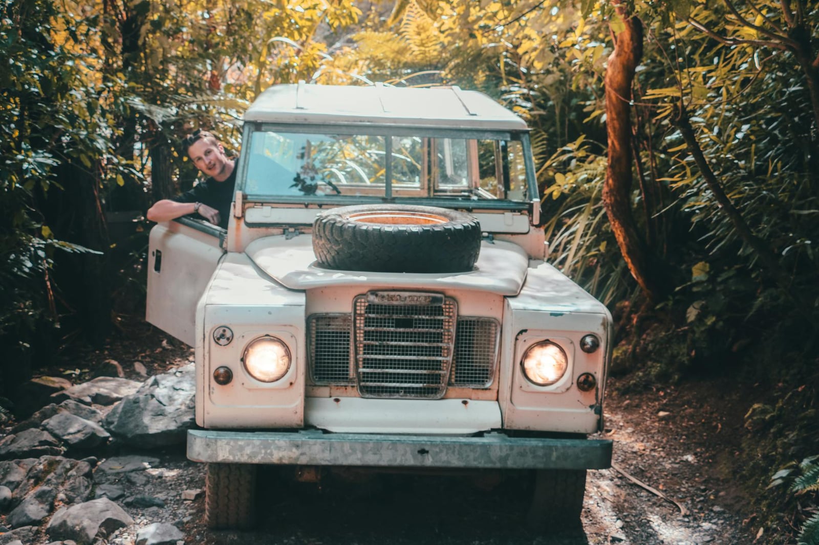 Front view of a pale Land Rover Series III with a spare wheel on the bonnet