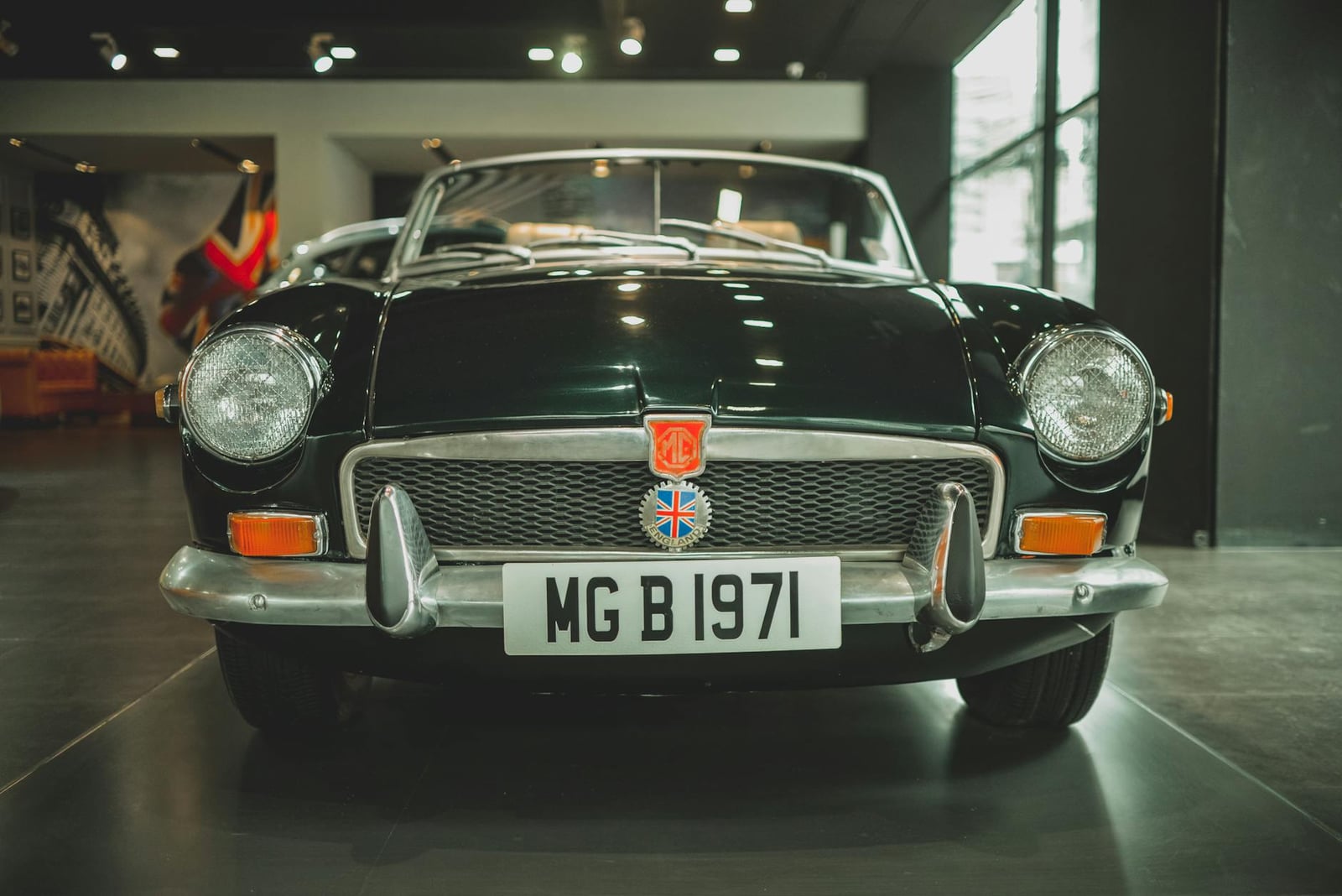 A dark green chrome-bumper MG MGB roadster seen head-on, its number plate reading MG B 1971