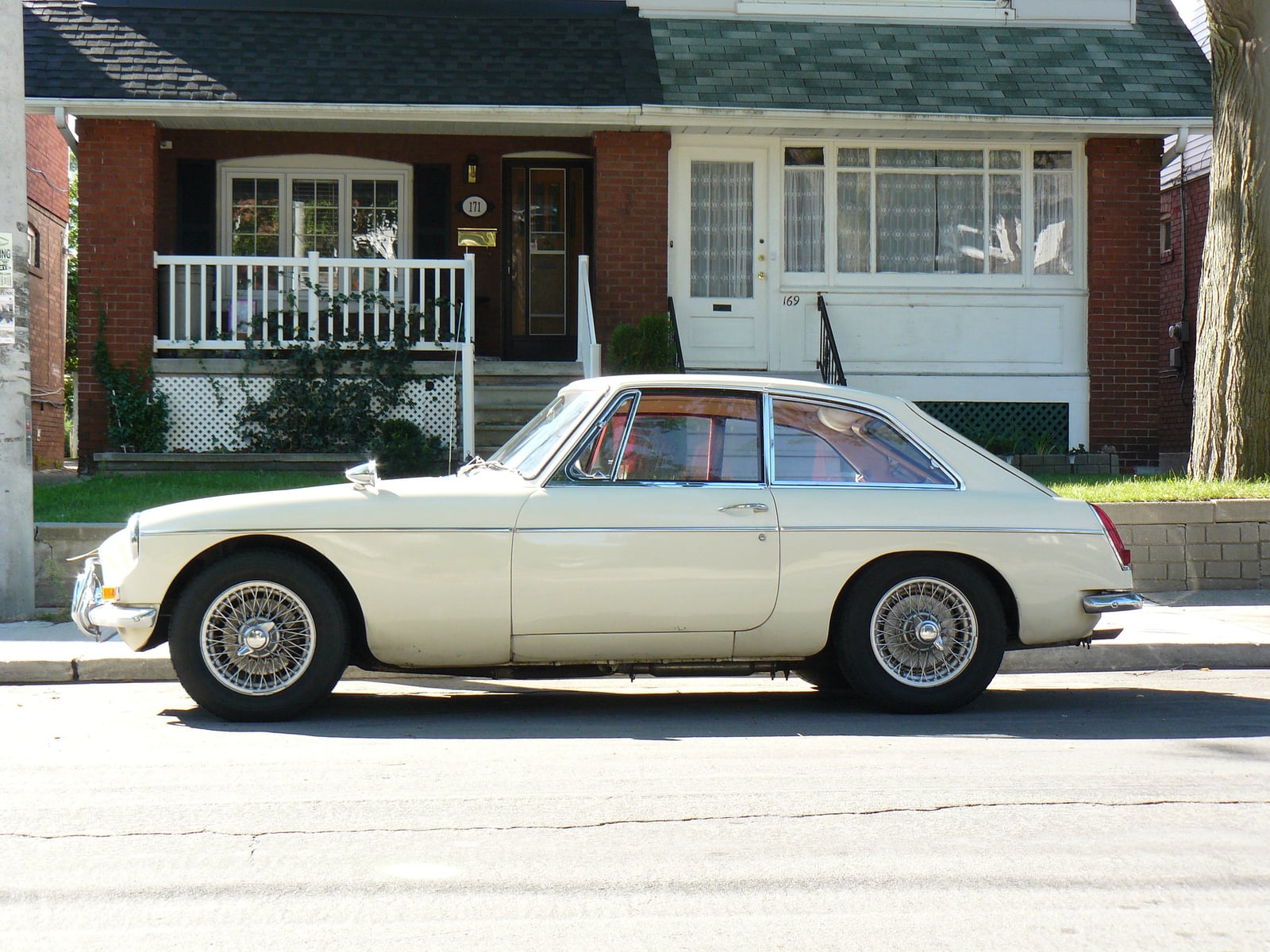 A cream MG MGB GT in side profile, showing the fastback roofline