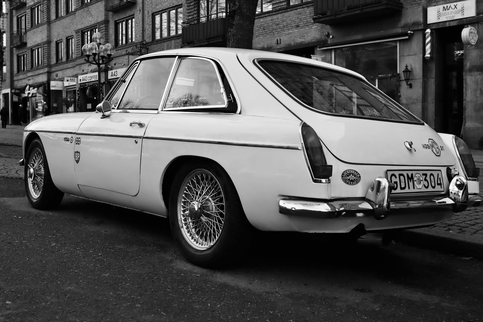 A white MG MGB GT, rear three-quarter view showing the hatchback tailgate