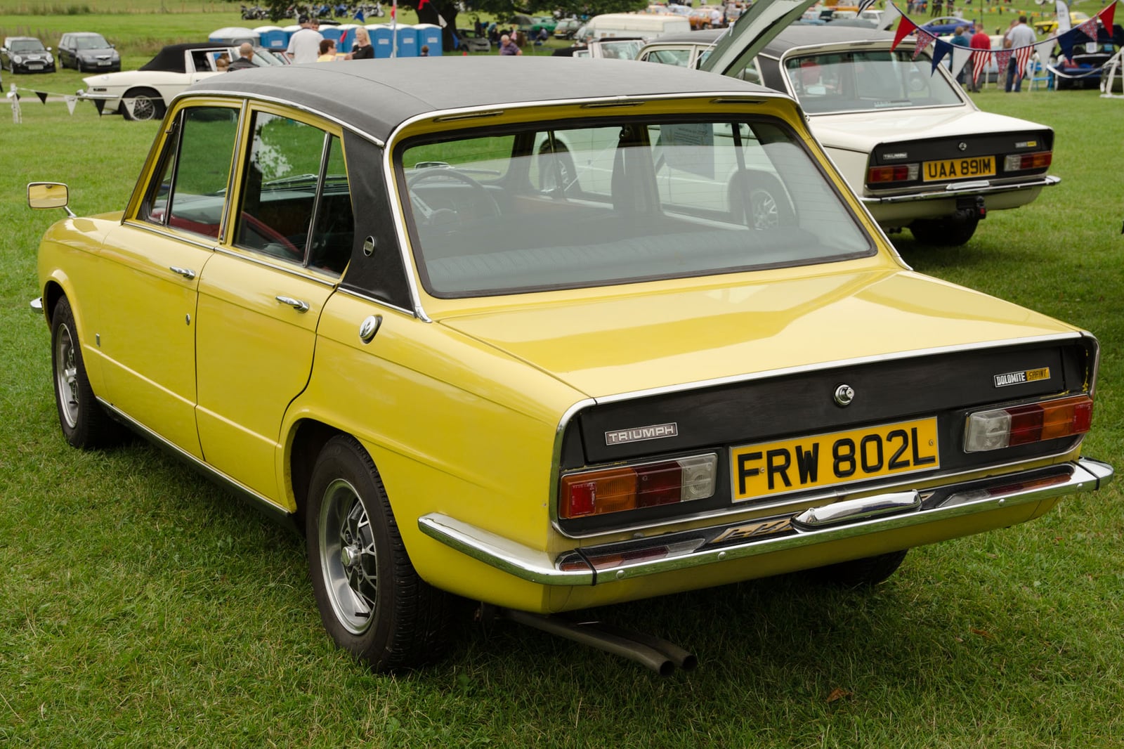 A yellow Triumph Dolomite Sprint, rear three-quarter view at a show