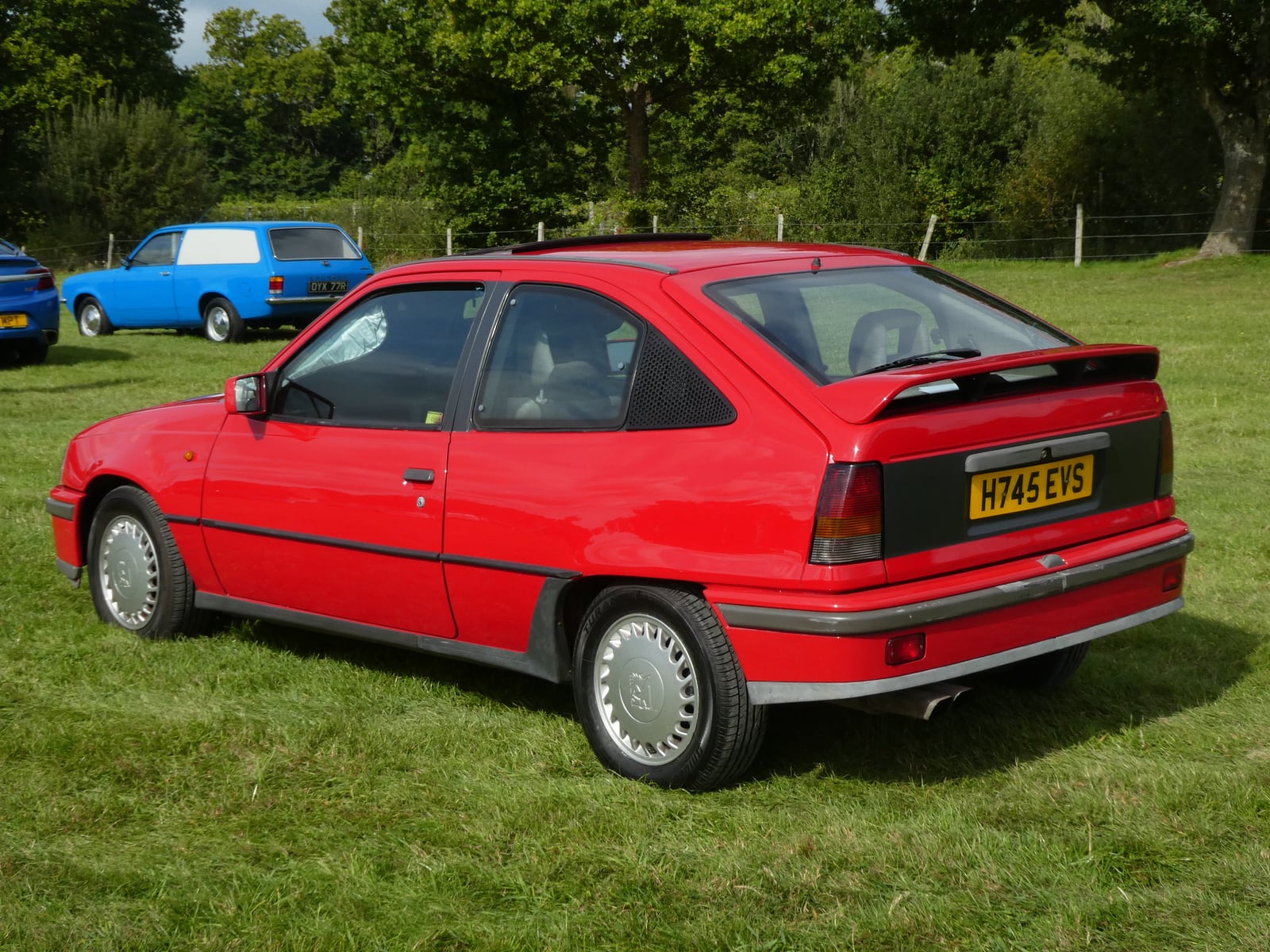 A red Vauxhall Astra GTE hatchback, rear three-quarter view on grass at a classic car show